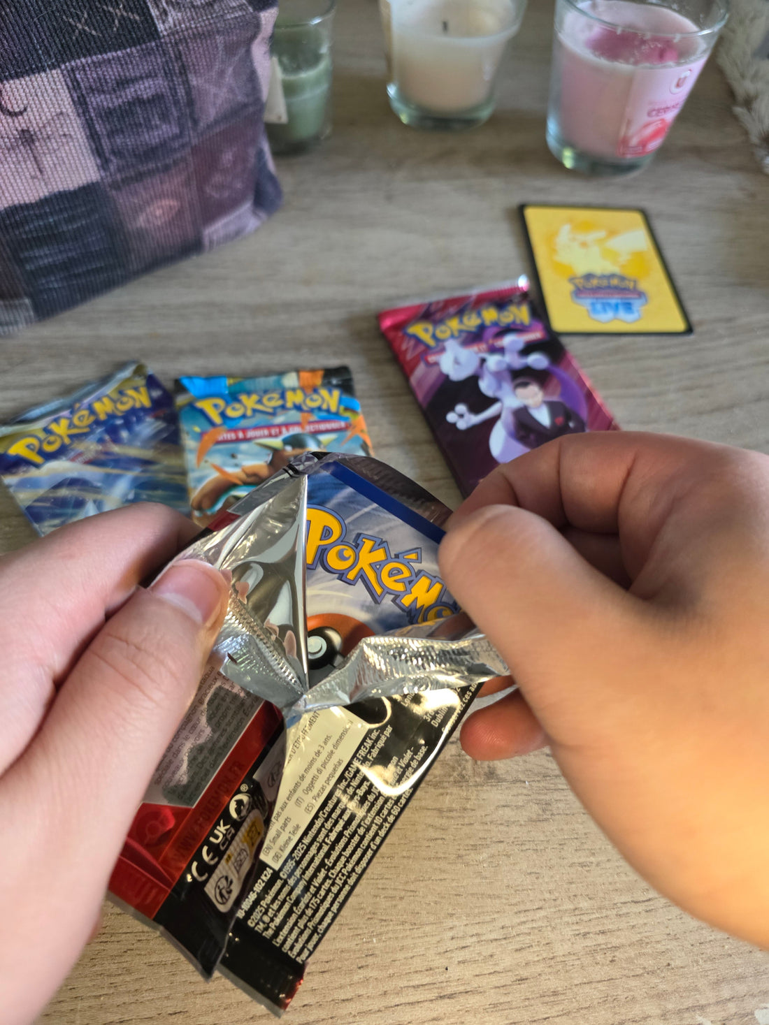 Des mains ouvrant des cartes Pokémon, première étape d'une collection